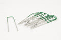 Set of metal needles with green handles on a white background